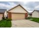View of a one-story home with a beige siding and a well-manicured front yard with healthy grass at 8116 Heritage Commons Dr # Bldg 24, Indianapolis, IN 46219