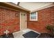A brick-walled front entrance featuring a storm door, lantern fixture, and a decorative welcome mat at 8116 Heritage Commons Dr # Bldg 24, Indianapolis, IN 46219