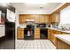 Cozy kitchen featuring light wood cabinetry and black appliances at 8116 Heritage Commons Dr # Bldg 24, Indianapolis, IN 46219