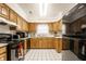 Fully-equipped kitchen with tile flooring, wood cabinets, and black appliances at 8116 Heritage Commons Dr # Bldg 24, Indianapolis, IN 46219