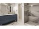 Modern bathroom featuring a double vanity with blue cabinets, gold fixtures, and luxurious gray marble-look shower at 861 S Park Trail Dr, Carmel, IN 46032