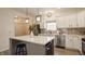 Bright kitchen featuring white cabinets, stainless steel appliances, a center island with bar stool, and stylish pendant lighting at 861 S Park Trail Dr, Carmel, IN 46032