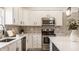 Well-appointed kitchen featuring stainless steel appliances, ample white cabinetry, stylish tile backsplash, and modern lighting fixtures at 861 S Park Trail Dr, Carmel, IN 46032