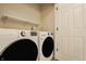 Well-equipped laundry room with front-loading washer and dryer, a shelf, and a clean, organized space at 861 S Park Trail Dr, Carmel, IN 46032