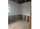 A partially renovated bedroom with exposed framing reveals insulation and plumbing below partially drywalled walls at 1016 Dawson St, Indianapolis, IN 46203