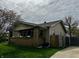 Charming home with a brick-accented porch, complemented by a well-maintained lawn and mature trees at 1020 N Colorado Ave, Indianapolis, IN 46201