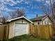 Detached garage featuring a paneled door, adjacent to a wooden fence and the home's exterior at 1020 N Colorado Ave, Indianapolis, IN 46201