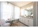 Light filled bathroom with a large vanity area, decorative rug and makeup table at 1099 Valentine Ln, Carmel, IN 46032
