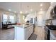 Bright, open kitchen with a central island, stainless steel appliances, and hardwood floors at 1099 Valentine Ln, Carmel, IN 46032