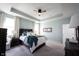 This main bedroom features a tray ceiling, a fan and large windows with white curtains at 1099 Valentine Ln, Carmel, IN 46032