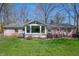 Manicured backyard with seating and dining area, large windows, and mature trees in view at 1109 Oakwood Trl, Indianapolis, IN 46260