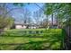 Large backyard with mature trees, a play-set, and lawn furniture creating a serene outdoor space at 1109 Oakwood Trl, Indianapolis, IN 46260