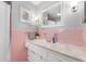 Bright pink vintage bathroom with an orchid, decorative art, and plenty of counter space at 1109 Oakwood Trl, Indianapolis, IN 46260