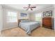 Bright bedroom with a ceiling fan, soft carpet, and natural light streaming through the windows at 1109 Oakwood Trl, Indianapolis, IN 46260