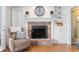 Living room brick fireplace with mantle, built-in shelving, and a cozy armchair at 1109 Oakwood Trl, Indianapolis, IN 46260