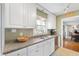 Traditional kitchen with white cabinets, granite countertops, stainless steel dishwasher, and window view at 1109 Oakwood Trl, Indianapolis, IN 46260