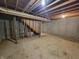 An unfinished basement with exposed ceiling joists and concrete walls with a staircase at 11152 Dura Dr, Indianapolis, IN 46229