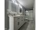 Modern bathroom featuring a double vanity with illuminated mirrors and a sleek glass-enclosed shower at 11152 Dura Dr, Indianapolis, IN 46229