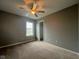 Neutral bedroom with a ceiling fan, window letting in natural light, and carpet flooring at 11152 Dura Dr, Indianapolis, IN 46229