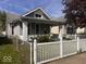 Inviting bungalow featuring a picket fence, landscaping, and classic architectural details at 1140 Hoyt Ave, Indianapolis, IN 46203