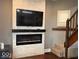 Living room featuring modern fireplace, TV, and staircase at 1140 Hoyt Ave, Indianapolis, IN 46203