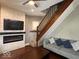 Cozy living room featuring a fireplace, TV, and wooden staircase at 1140 Hoyt Ave, Indianapolis, IN 46203