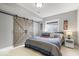 Bedroom showcasing a sliding barn door, window, and comfortable bed, creating a rustic, cozy retreat at 11410 Sea Side Dr, Fishers, IN 46040
