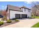 Side exterior view of the home featuring a three-car garage and well-manicured landscaping at 11410 Sea Side Dr, Fishers, IN 46040