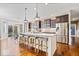 Spacious kitchen with a large island, stainless steel appliances, dark cabinets, and wood flooring at 11410 Sea Side Dr, Fishers, IN 46040