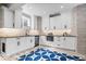 Basement kitchen with white cabinets, stone backsplash, stainless appliances and blue pattern rug at 11410 Sea Side Dr, Fishers, IN 46040