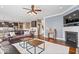 Open floor plan features a shiplap accent wall, fireplace, and hardwood floors connecting the living room and kitchen at 11410 Sea Side Dr, Fishers, IN 46040