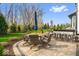 Beautiful outdoor patio area with dining set, umbrellas, and outdoor kitchen with bar seating, surrounded by lush greenery at 11410 Sea Side Dr, Fishers, IN 46040
