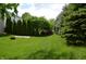 Lush green backyard with mature trees and a fire pit area creating a tranquil outdoor setting at 12326 River Valley Dr, Fishers, IN 46037