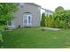 Serene backyard with lush green grass, mature trees, a bay window, and a charming fire pit area at 12326 River Valley Dr, Fishers, IN 46037