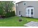 Spacious backyard featuring a well-maintained lawn, privacy trees, a patio, and a cozy fire pit at 12326 River Valley Dr, Fishers, IN 46037