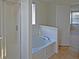 Bright bathroom featuring a glass-enclosed shower and separate soaking tub under a window at 12326 River Valley Dr, Fishers, IN 46037