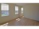 Sunlit bedroom with wood-look flooring, multiple windows, and neutral paint at 12326 River Valley Dr, Fishers, IN 46037