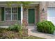 Inviting front entrance with a green door, brick accents, and well-maintained garden bed at 12326 River Valley Dr, Fishers, IN 46037