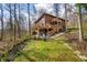 Backyard with stairs leading to a deck, chairs, fire pit, and surrounding trees at 13306 W 50 S, Columbus, IN 47201