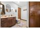 A well-lit bathroom features a wood vanity, framed mirror, and neutral-toned walls and flooring at 13306 W 50 S, Columbus, IN 47201