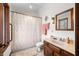 Bright bathroom features a vanity with wood cabinets, shower and tub combination, and neutral colored walls at 13306 W 50 S, Columbus, IN 47201