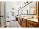 Bathroom with wood vanity, a large mirror, and tile flooring, featuring neutral wall colors and ample lighting at 13306 W 50 S, Columbus, IN 47201