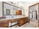 Bathroom featuring a long vanity with ample storage, a large mirror, and a tiled floor at 13306 W 50 S, Columbus, IN 47201