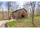 Side view of a two-story house showing garage and deck surrounded by tall trees at 13306 W 50 S, Columbus, IN 47201