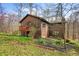View of a home's side with greenery, a deck, and the surrounding woods at 13306 W 50 S, Columbus, IN 47201