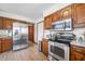 Well-lit kitchen with stainless steel appliances and wood cabinets at 13306 W 50 S, Columbus, IN 47201