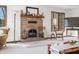This living room features a brick fireplace with mantel, large windows, and warm, inviting decor at 13306 W 50 S, Columbus, IN 47201