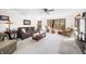 Bright living room featuring a brown leather sofa, plush armchairs, and large windows with beautiful wooded views at 13306 W 50 S, Columbus, IN 47201