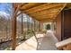 A view of the covered outdoor patio space with porch swing and wooded surrounding at 13306 W 50 S, Columbus, IN 47201