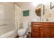 Well-lit bathroom featuring a wood vanity, shower with curtain, and round mirror at 14195 Holly Berry Cir, Fishers, IN 46038